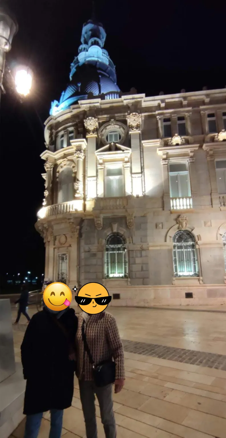 Foto nocturna en Cartagena con un edificio modernista iluminado en el fondo durante nuestro viaje por España.