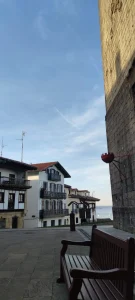 Banco de madera junto al mar con casas típicas en Hondarribia.