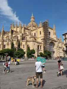 Vista de la Catedral de Segovia desde un mirador, con miembros de la familia disfrutando del paisaje bajo un cielo despejado.