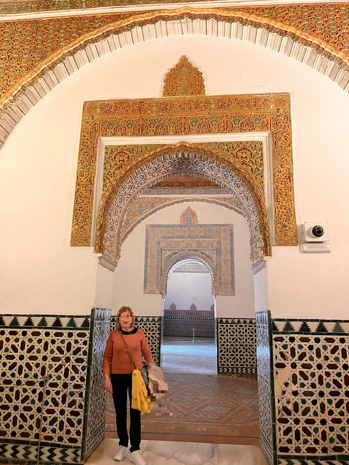 Detalle de los arcos decorados del interior del Real Alcázar de Sevilla, con inscripciones y azulejos andalusíes.