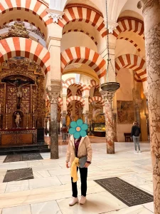 Mi madre frente al retablo dorado con crucifijo en la Mezquita-Catedral de Córdoba