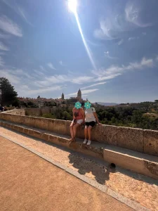 Vista de la Catedral de Segovia desde un mirador, con miembros de mi familia disfrutando del paisaje bajo un cielo despejado.