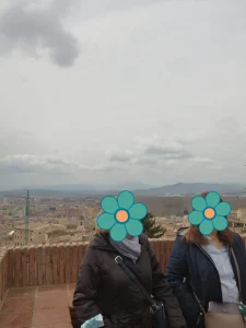 Panorámica de Girona desde el mirador con nubes y montañas al fondo.