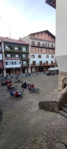 Plaza con escalinata y terrazas en Hondarribia al atardecer.